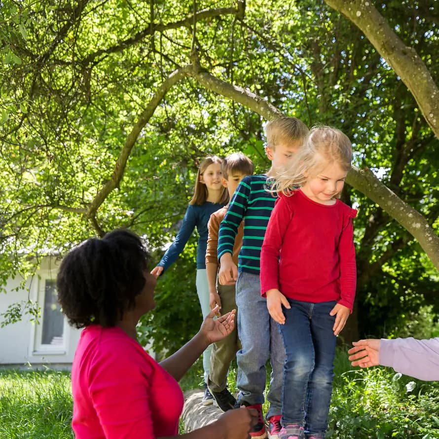Stiftungsfonds Kinder balancieren unter Aufsicht auf einem Ast