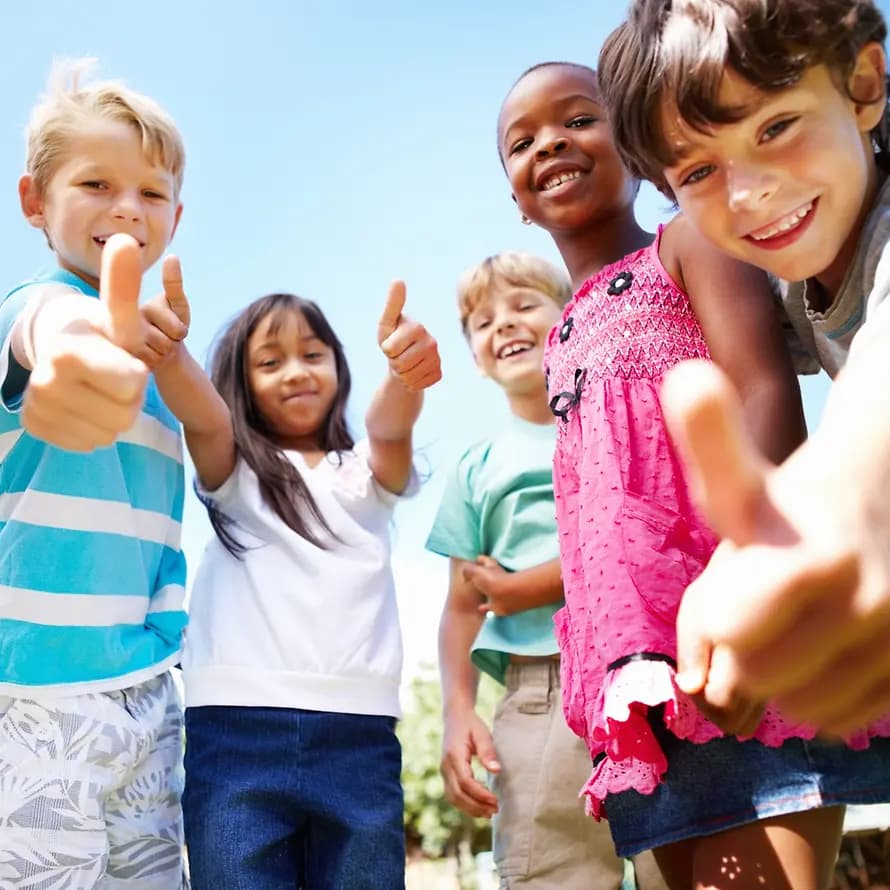 68012_iStock-GoodboyPictureCompany_155145325.jpg Kinder lachen und halten die Daumen hoch.