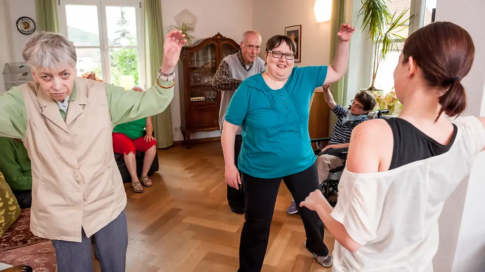 Bewohner der Dorfgemeinschaft Hohenroth Bewohner der Dorfgemeinschaft Hohenroth bei Bewegungsübungen im Wohnzimmer
